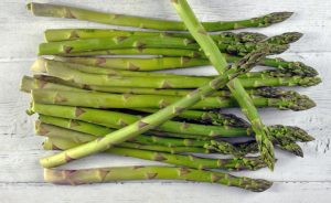 Verse groene asperges op een witte houten ondergrond, geschikt voor recepten met asperges