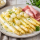 Witte asperges met zilveruitjes, ham en botersaus op een bord geserveerd als klassieke lentemaaltijd