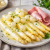 Witte asperges met zilveruitjes, ham en botersaus op een bord geserveerd als klassieke lentemaaltijd